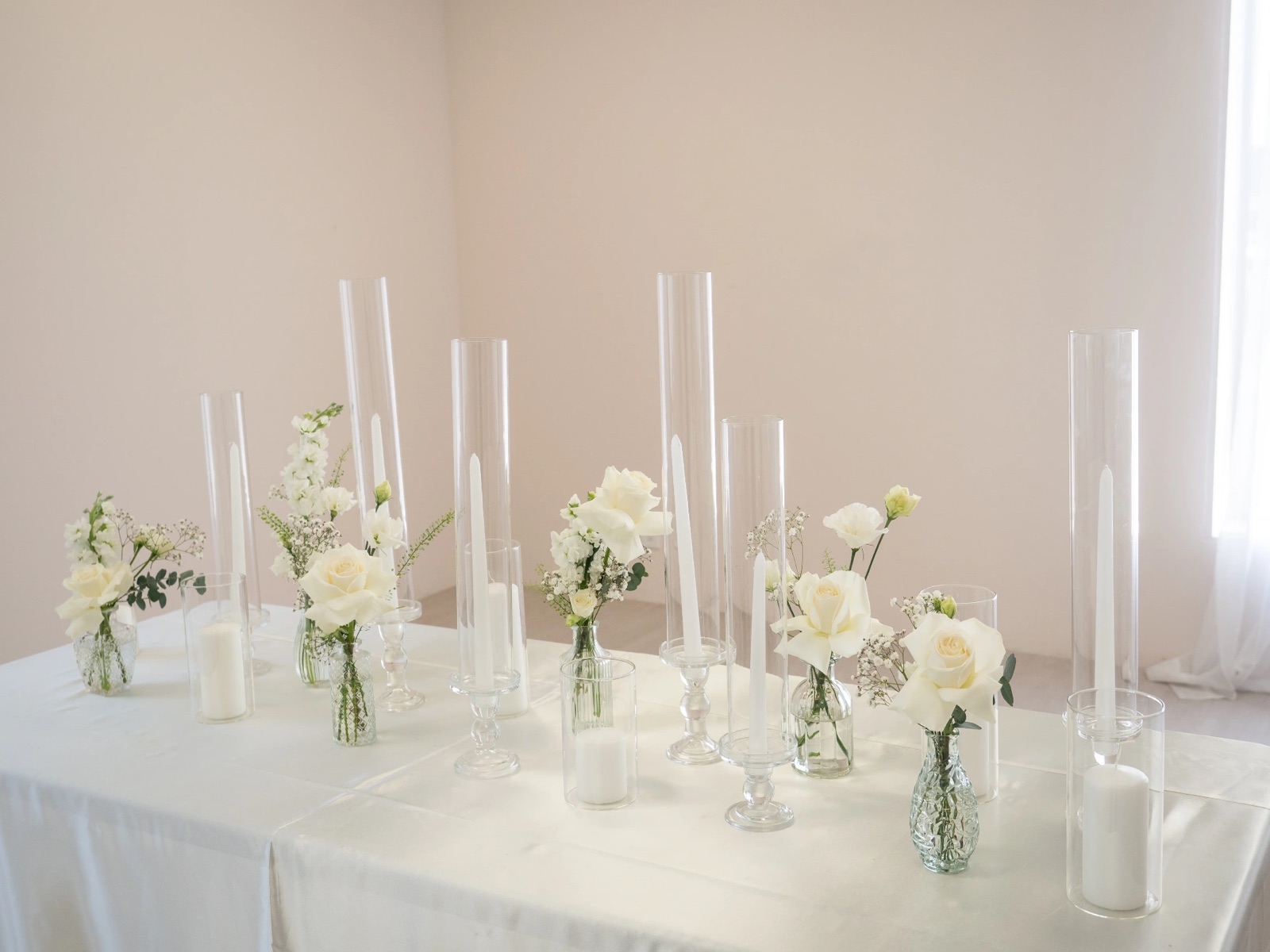 Candles and white flowers on a long table.