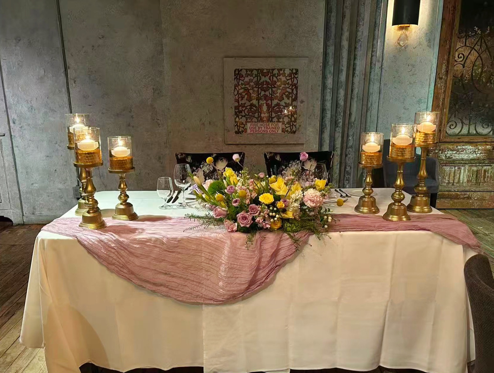A candlelit table in a stone-walled dining room.