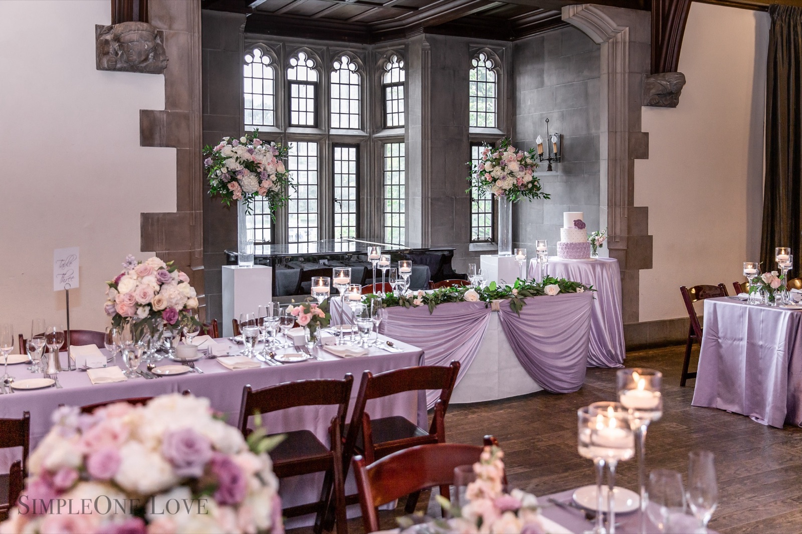 Long tables in a Gothic hall with leaded windows.