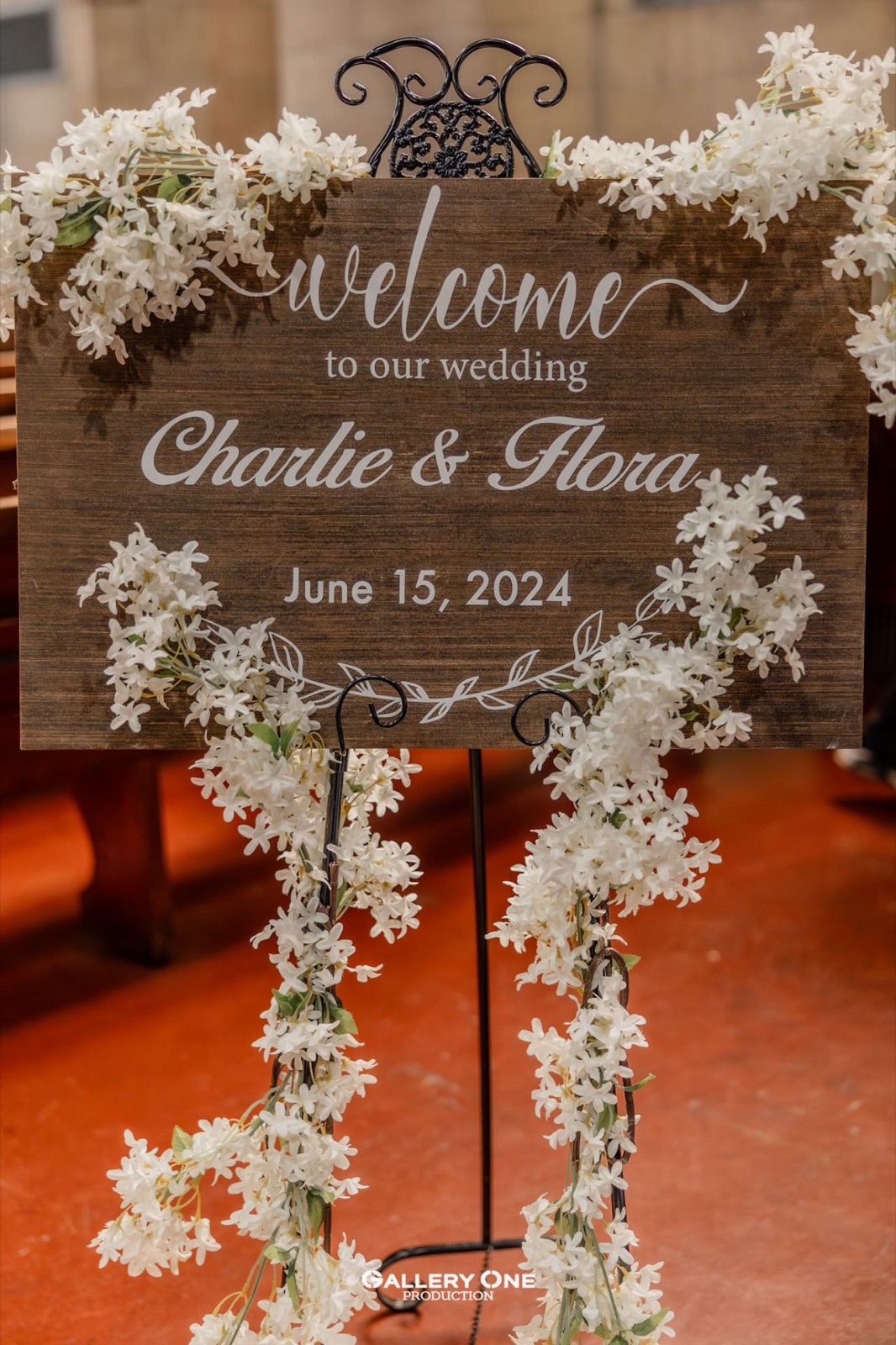 A welcome sign wrapped in white flowers at the entrance.