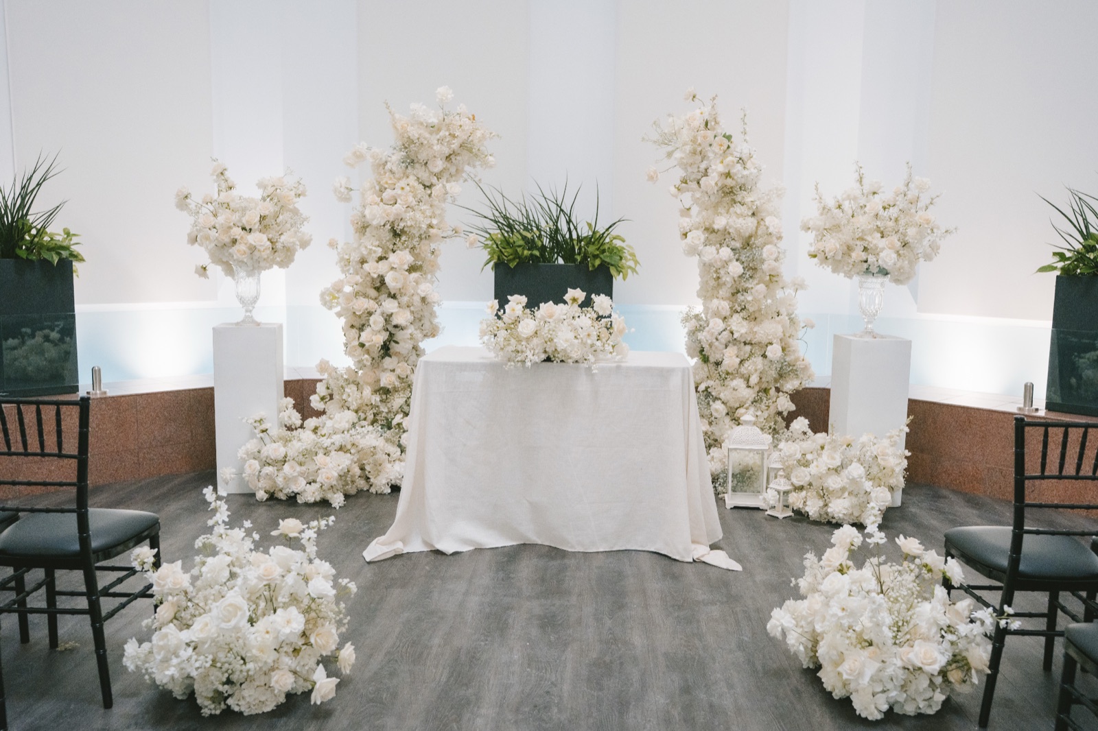 A room at the civic centre dressed with flower columns around a small table.
