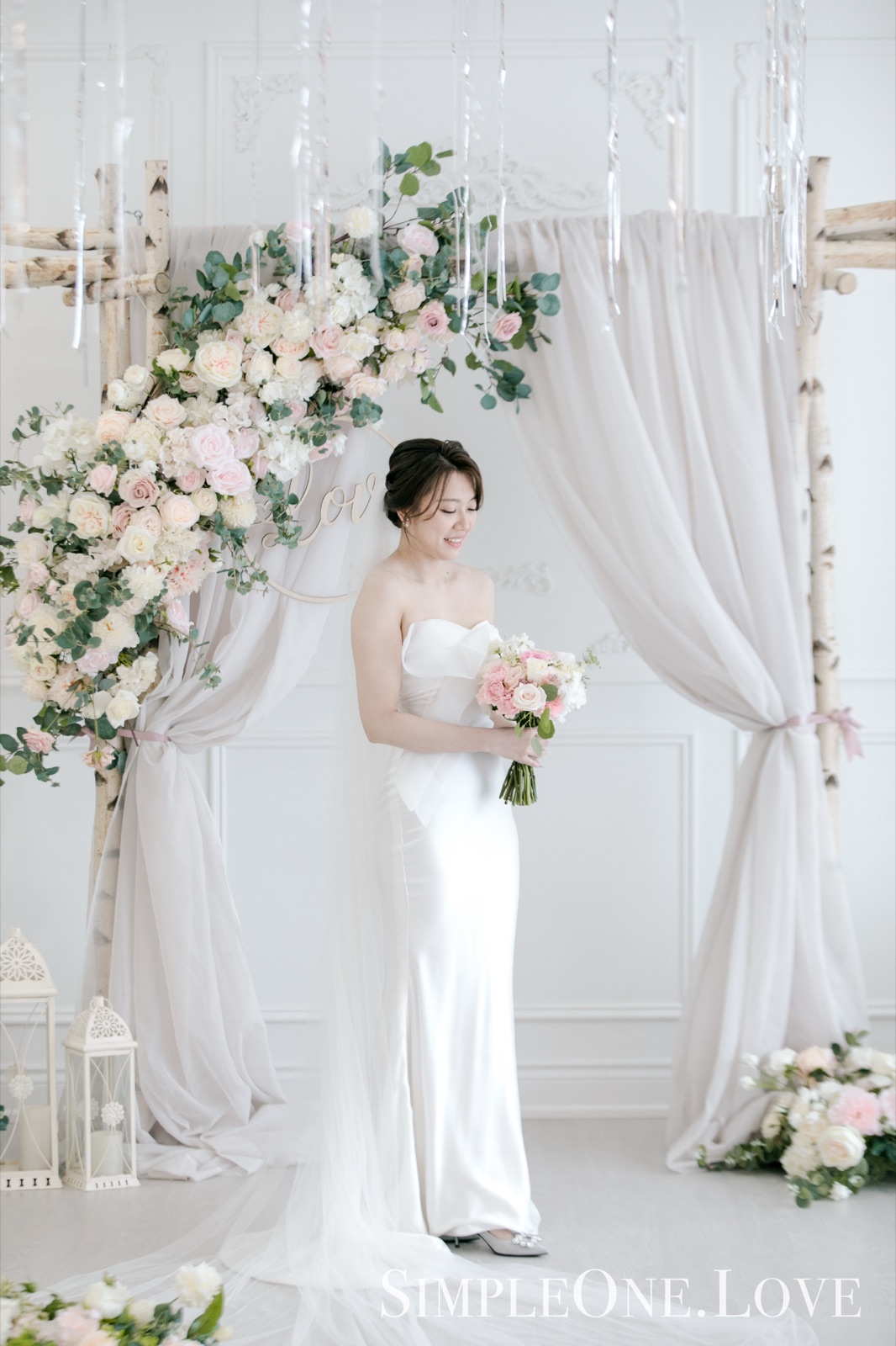 A bride under a flower arch at the chapel's front.