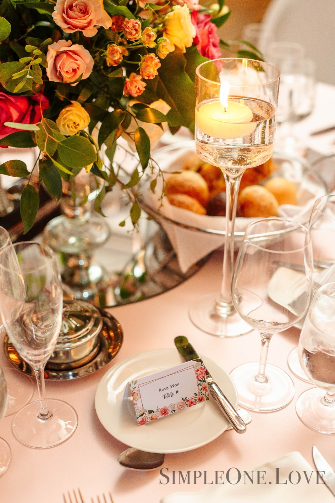 Pastries, candles and roses on a set table.